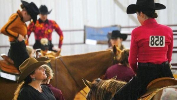 a group of people in western hats riding horses